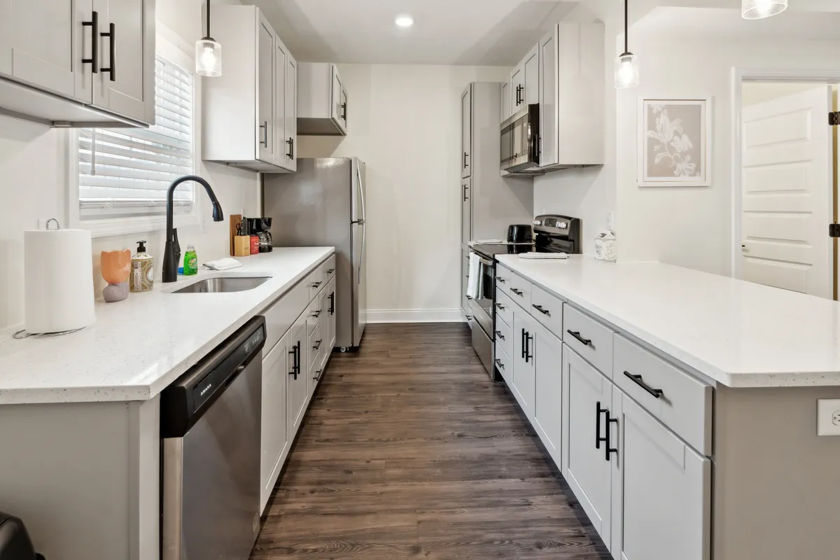A beautifully designed kitchen featuring a prominent island, gleaming stainless steel appliances, and modern cabinetry. The space is arranged for cooking, family gatherings, and entertaining, with a warm and inviting atmosphere.